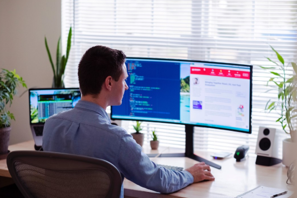 man in front of computer working remotely