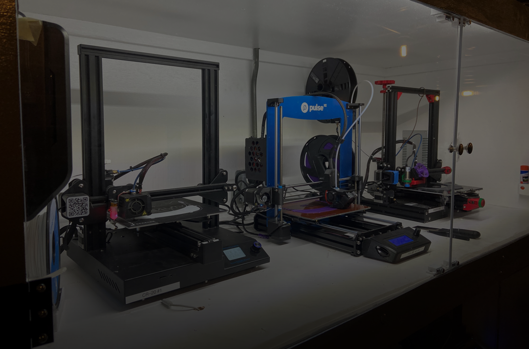 Three 3D Printers inside glass case