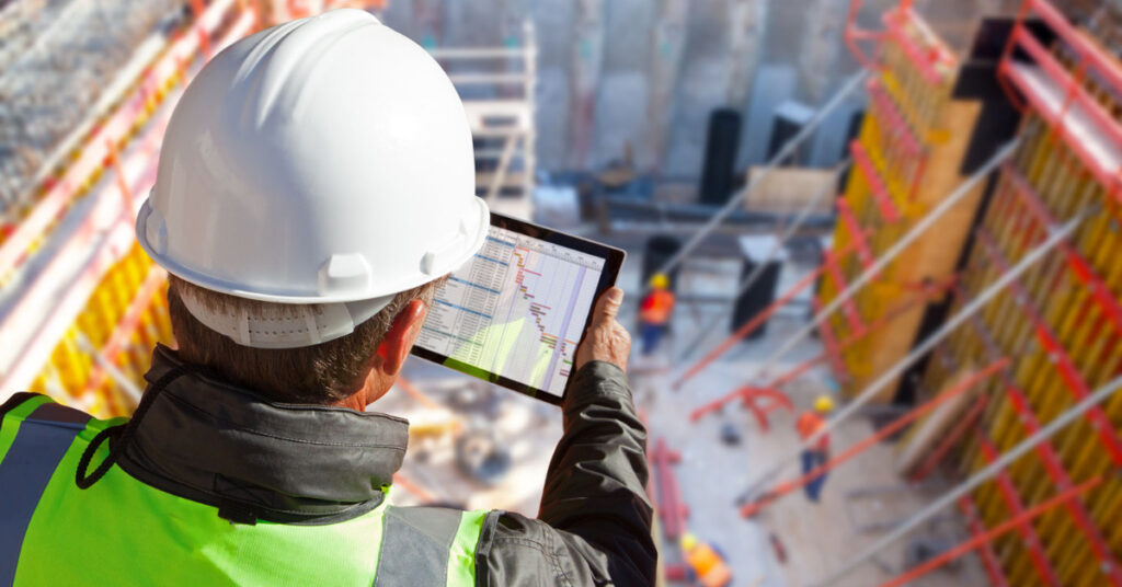 Construction worker looking at BIM model on tablet.